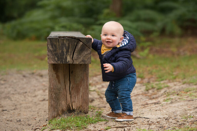 Baby holding onto a bench outdoors, at 9 months old, is another good option when choosing the best age for newborn photography and older baby photoshoots